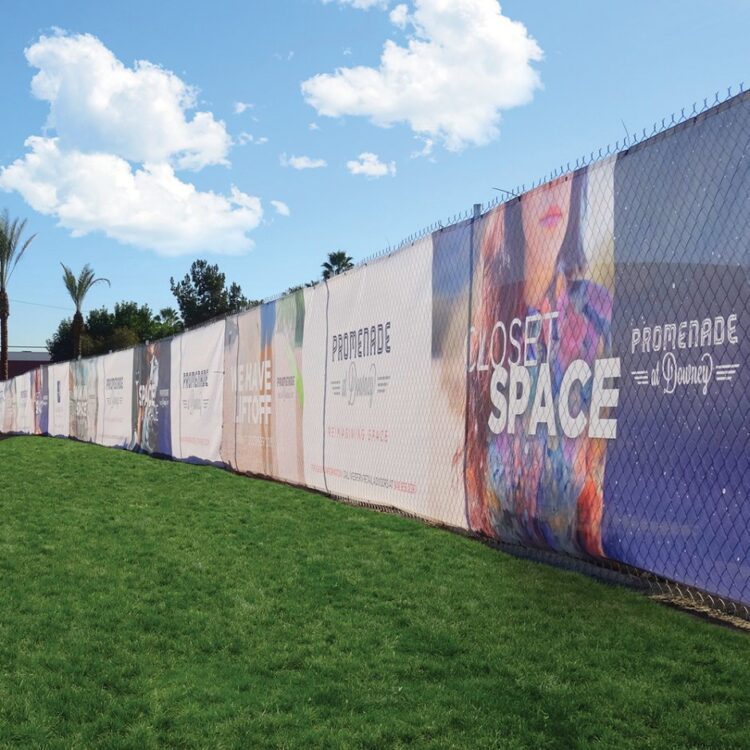 baner siatkowy mesh z kolorowym nadrukiem zamocowany na ogrodzeniu