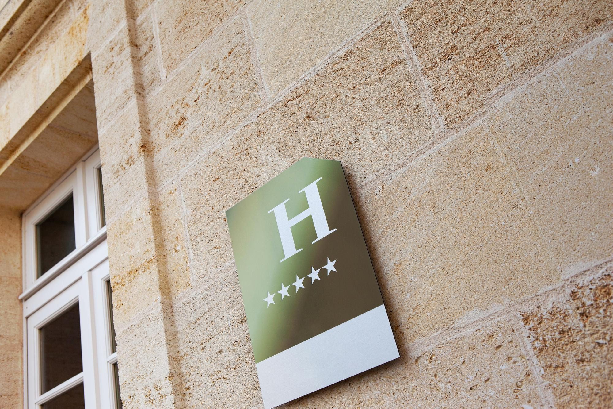 Tablica informacyjna z logotypem firmy zamontowana przy wejściu do hotelu firmy