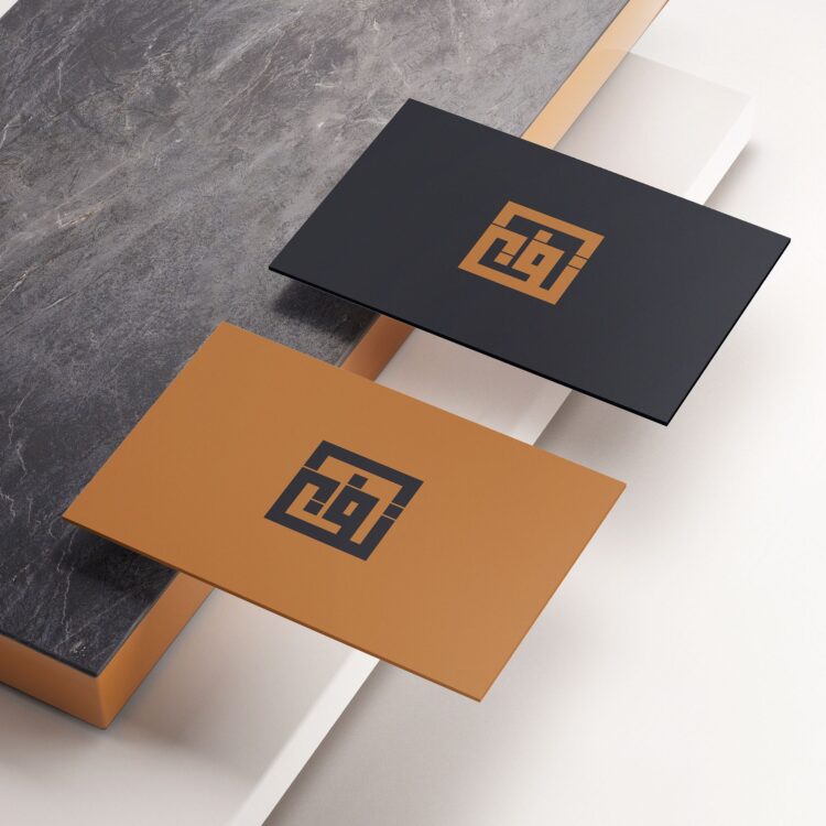 Dwie wizytówki w kolorze czarnym i miedzianym z logo