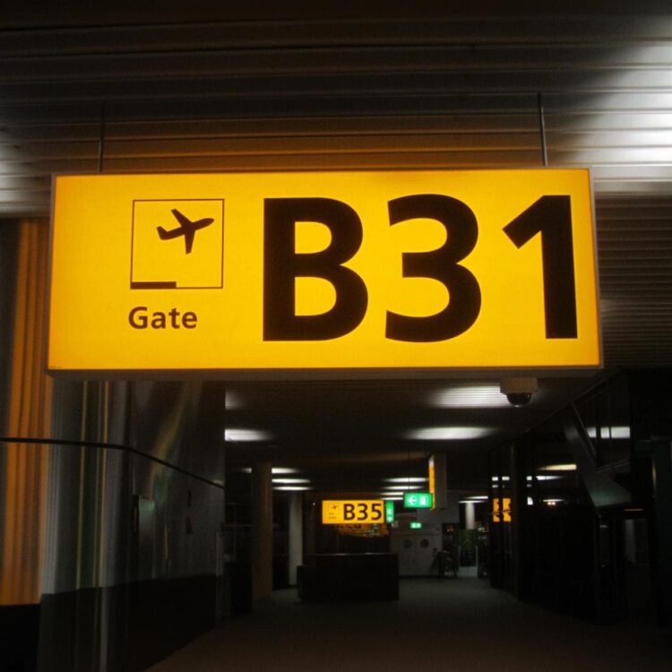 Żółto-czarny kaseton świetlny LED wykonany z plexi, zamontowany na zewnątrz budynku jako elegancka forma reklamy wizualnej.