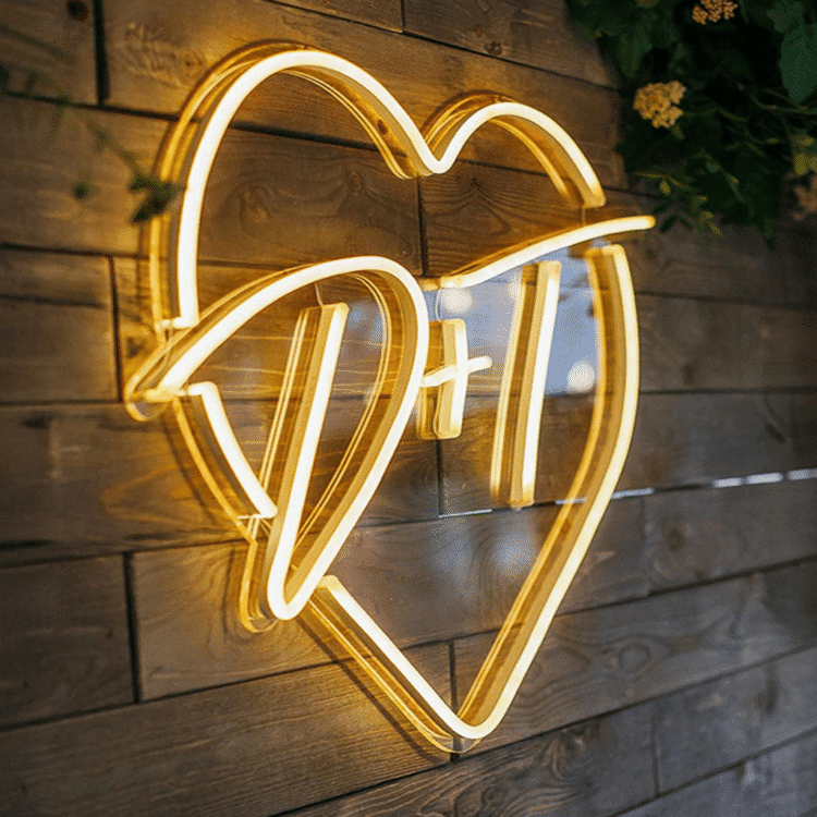 Żółty neon LED w kształcie serca, zamontowany na przezroczystej plexi i drewnianej ścianie – dekoracja ścienna do wnętrz.