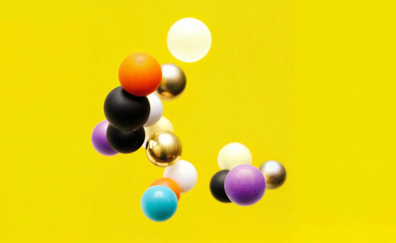 Kolorowe kule na żółtym tle jako abstrakcyjny motyw wizualny marki Illan Unity.