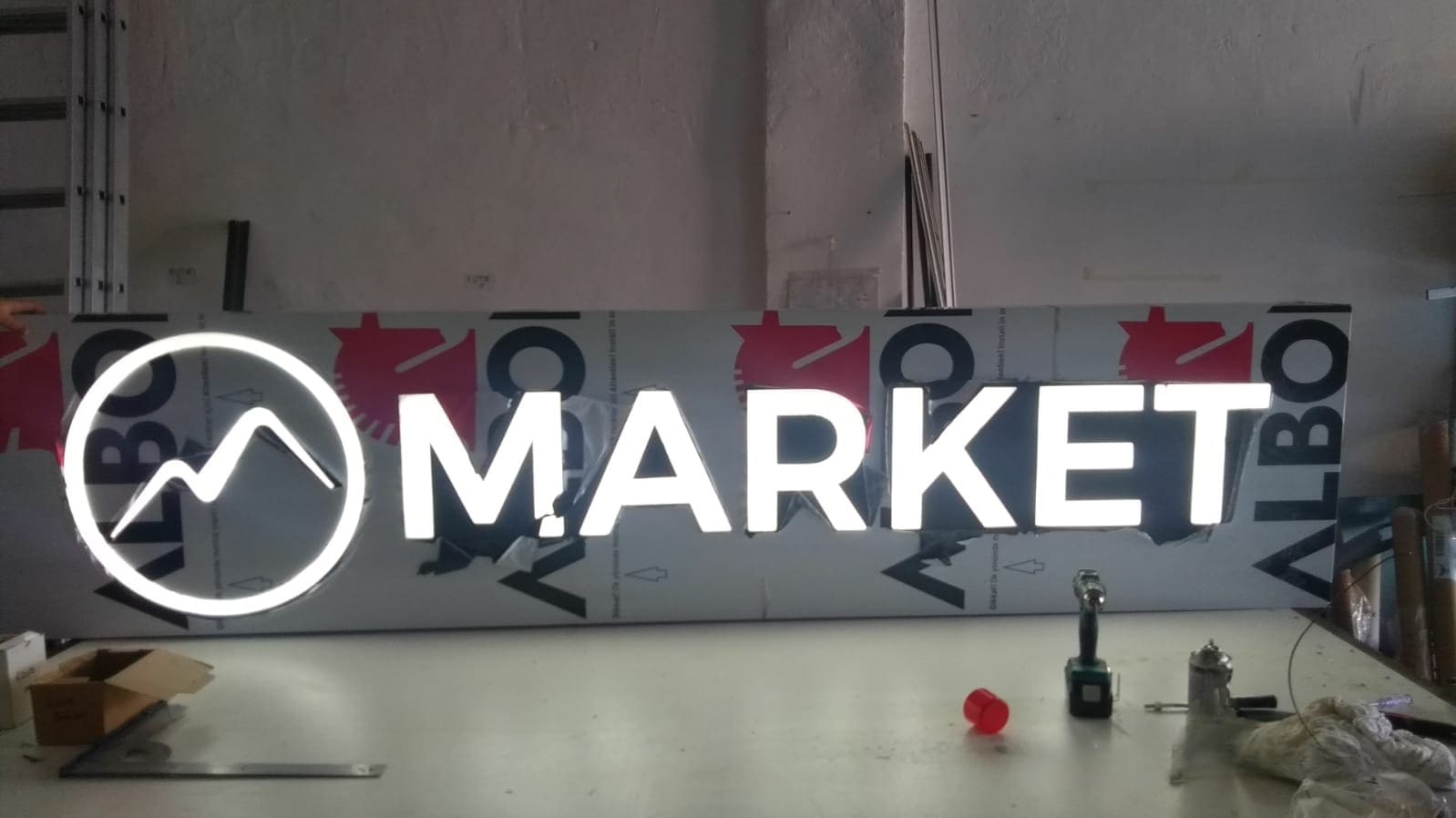 Realizacja szyldu dla sklepu MARKET — nowoczesny kaseton wykonany z odpornego na warunki atmosferyczne dibondu, z literami 3D podświetlanymi energooszczędnym oświetleniem LED.