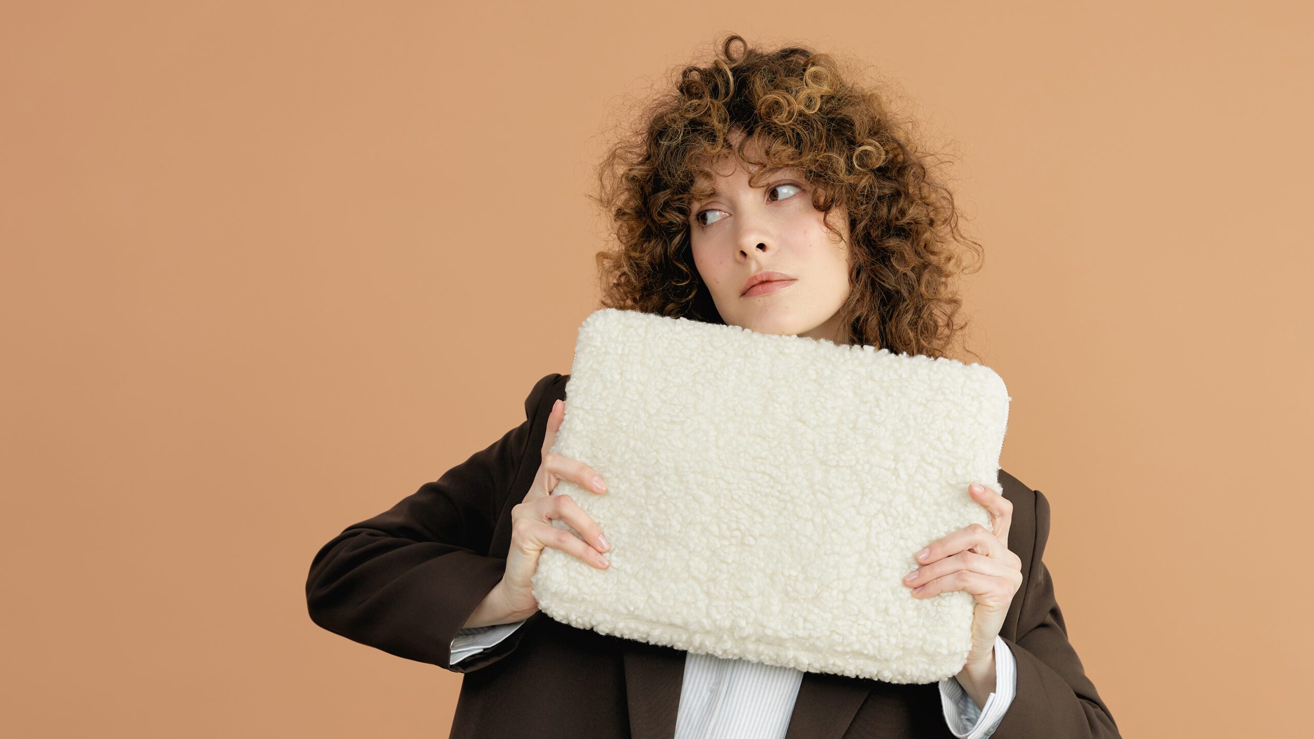 Modelka trzyma miękką futrzaną torbę TEDDY w kampanii brandingowej marki modowej.