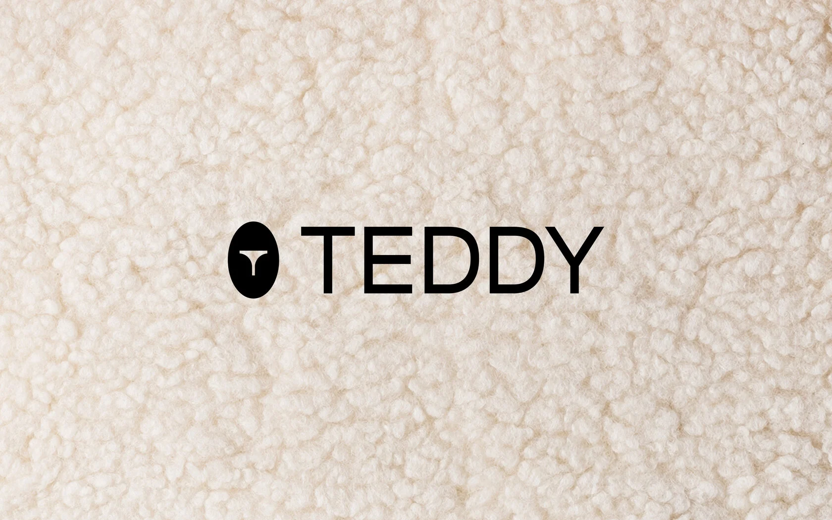 Logo marki TEDDY na tle miękkiej faktury materiału imitującego futro.